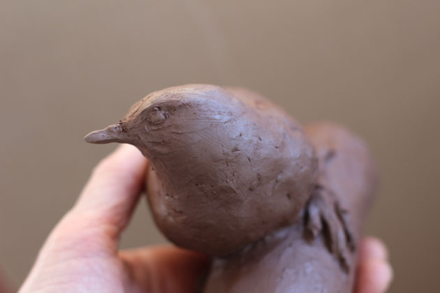 Working on a clay model for a bird sculpture
