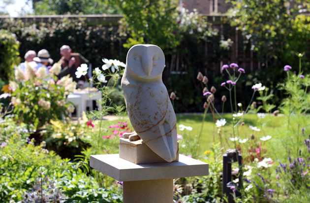 Owl sculpture among flowers