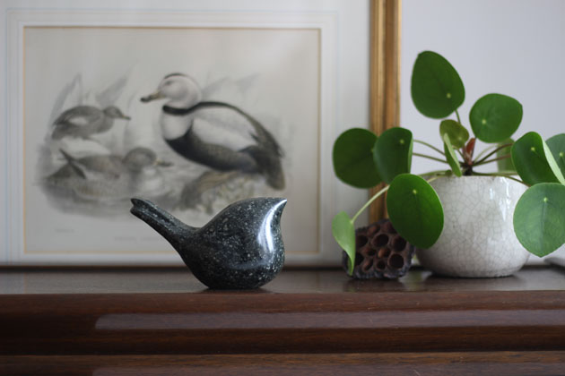 Bird sculpture perched on the bookcase