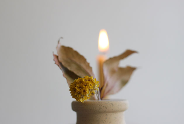 Natural beeswax candle in stone holder